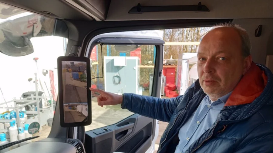 Weidlich Geschäftsführer Olaf Langer in einer LKW Fahrerkabine mit Sicherheitskamera-Display | Drinkport
